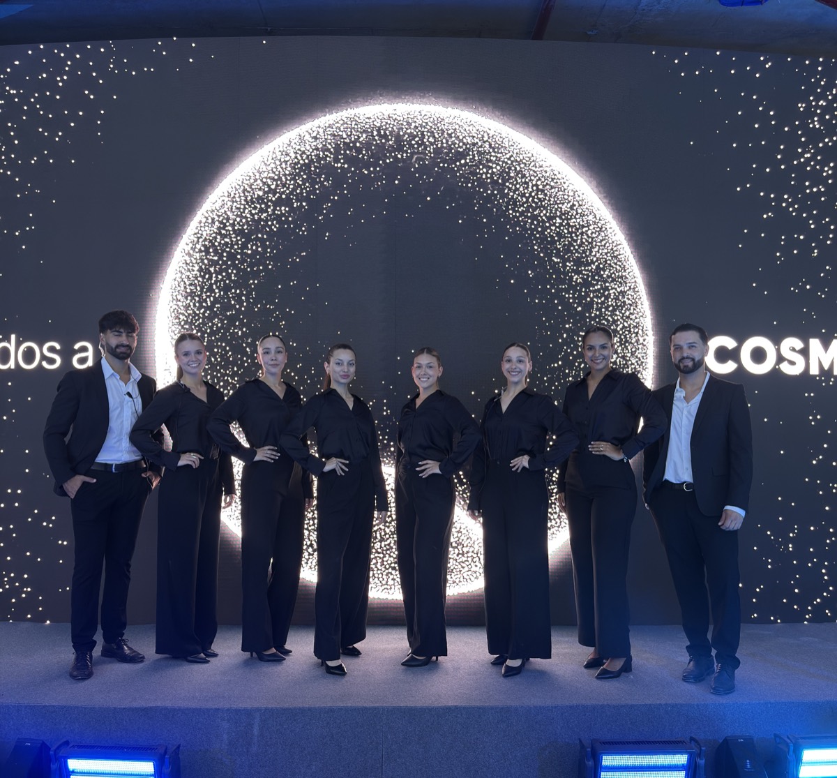 Equipo de traje oscuro frente a una instalación circular de luces.
