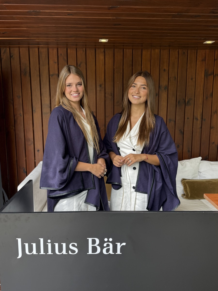 Dos anfitrionas frente al cartel de Julius Bär.