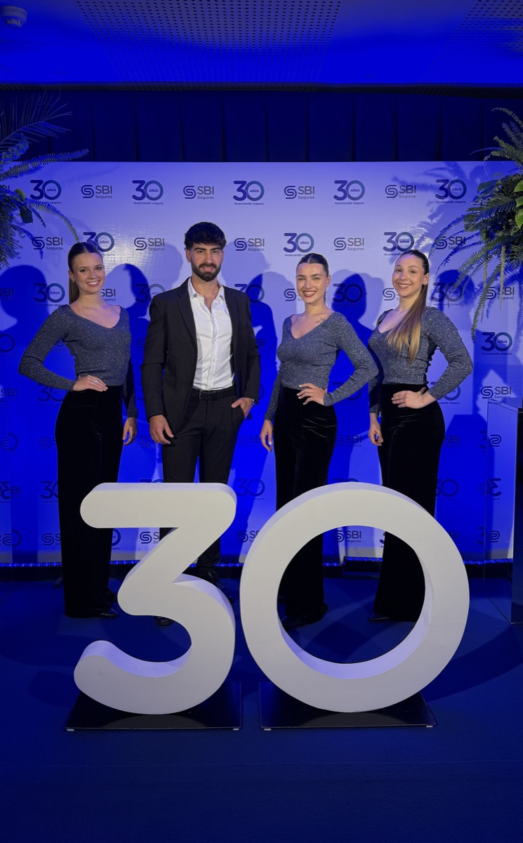 Equipo frente a un número 30 iluminado, en el aniversario de SBI Seguros.