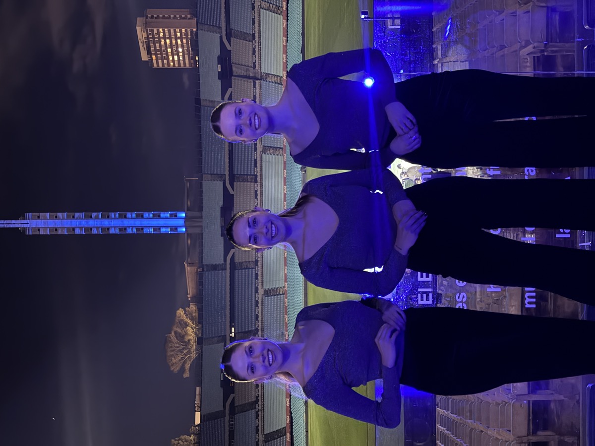 Tres promotoras de violeta en un evento nocturno de Volkswagen.